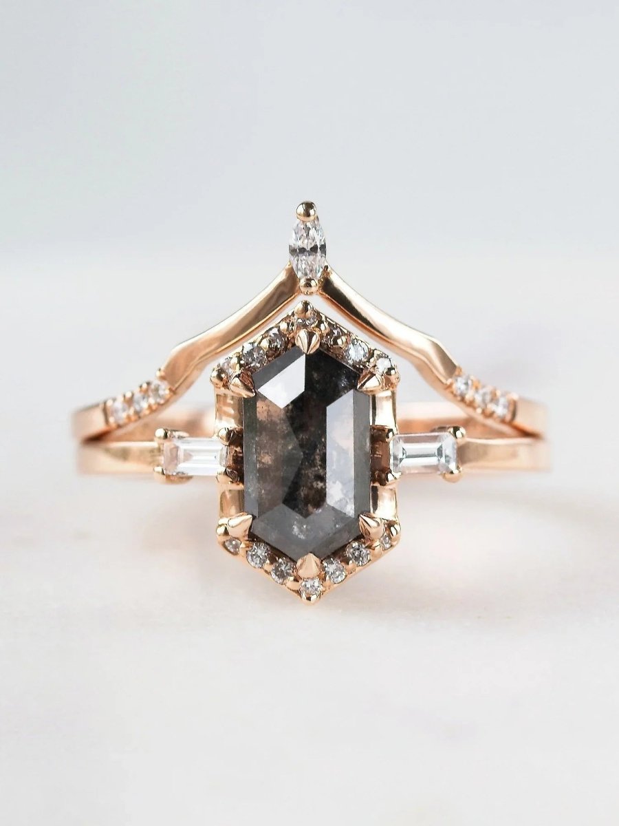 Rose gold ring with a central diamond and smaller diamonds on a light gray background