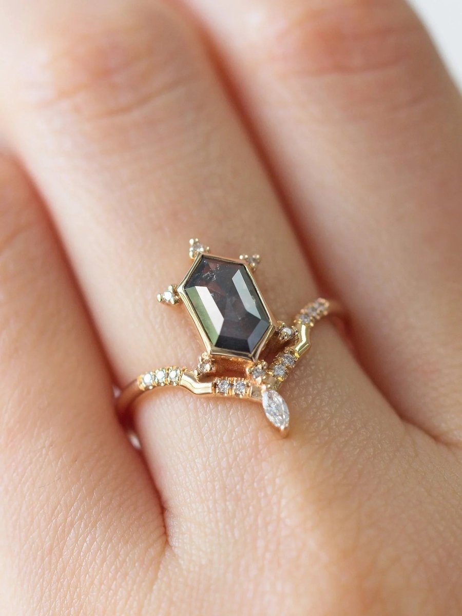 Unique art deco styled hexagon salt and pepper diamond engagement ring in 14k rose gold with a marquise and round diamonds on model's hand.