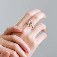 Unique art deco styled hexagon salt and pepper diamond engagement ring in 14k rose gold with six marquise and two baguette diamonds on model's hand.