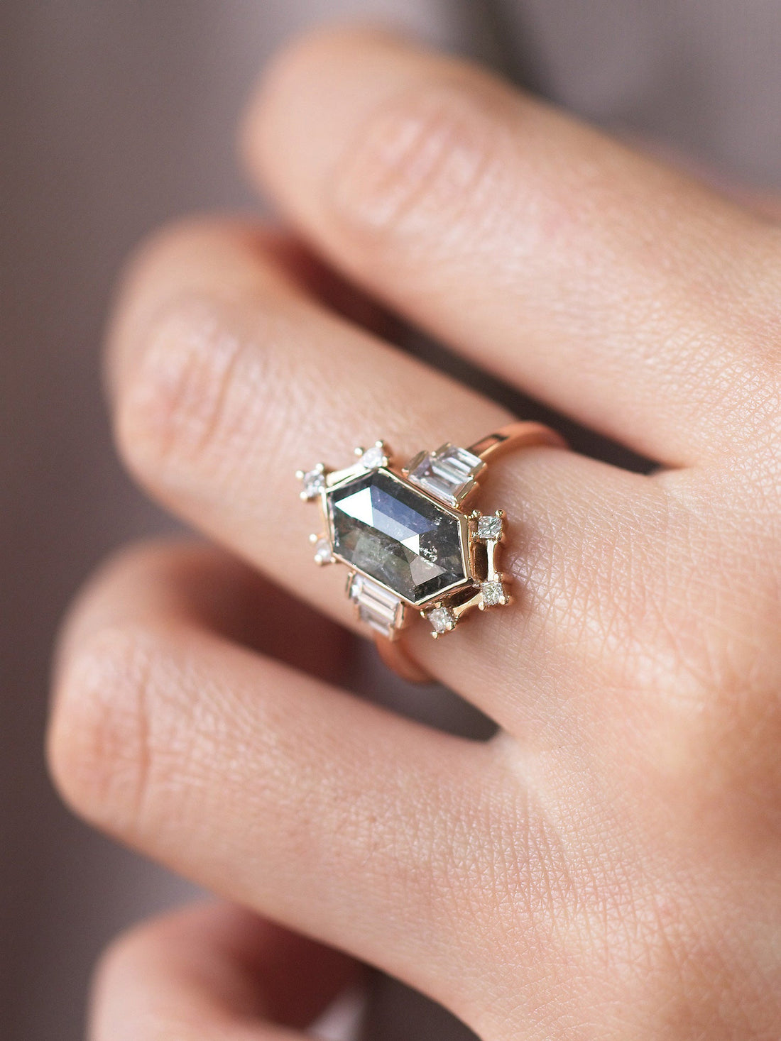 Minimalistic and art deco styled hexagon salt and pepper diamond engagement ring in 14k rose gold with princess and baguette diamonds on model&