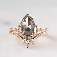 Pear-shaped salt and pepper diamond engagement ring in 14k rose gold  with matching band inspired by the art deco style and minimalism. 