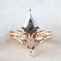 Minimalistic and art deco styled kite salt and pepper diamond engagement ring in 14k rose gold with a trilliant and round diamonds with matching band.