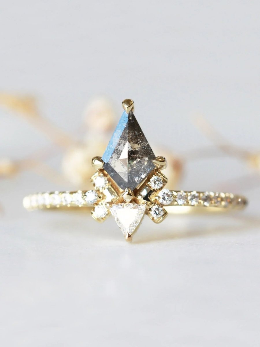 Gold ring with a central diamond and smaller diamonds on a light background