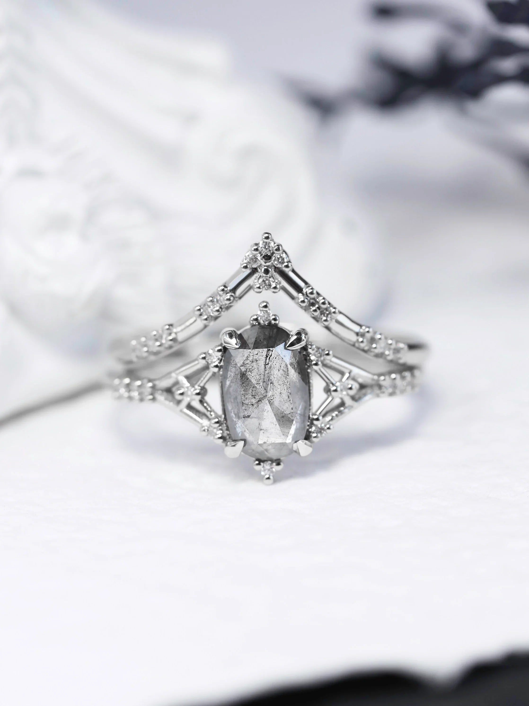 Art deco minimalistic oval salt and pepper diamond engagement ring in 14k rose gold with smaller round diamonds.