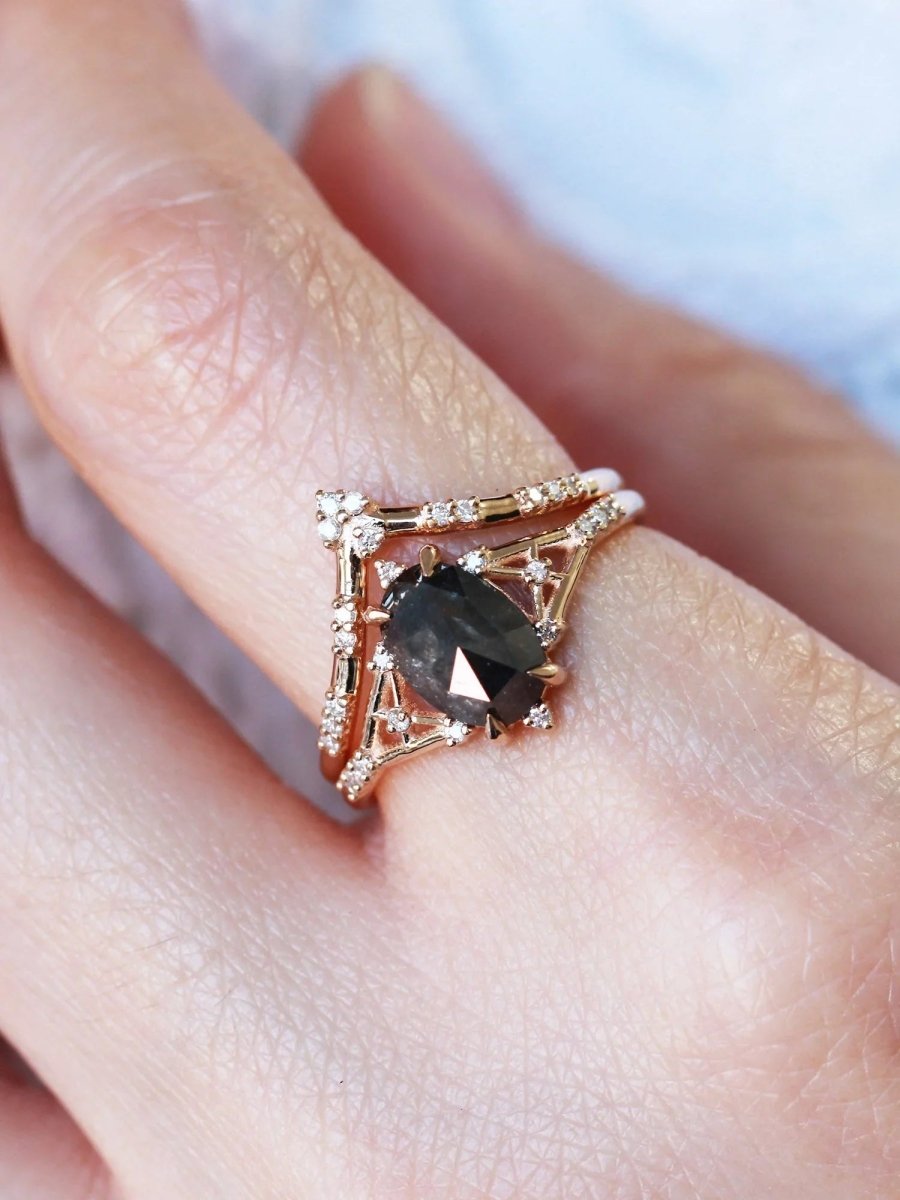 Art deco minimalistic oval salt and pepper diamond engagement ring in 14k rose gold with smaller round diamonds.