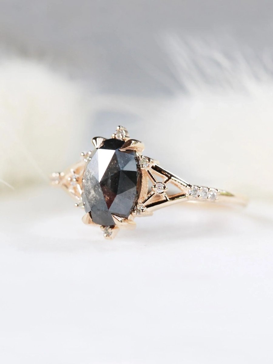Art deco minimalistic oval salt and pepper diamond engagement ring in 14k rose gold with smaller round diamonds.