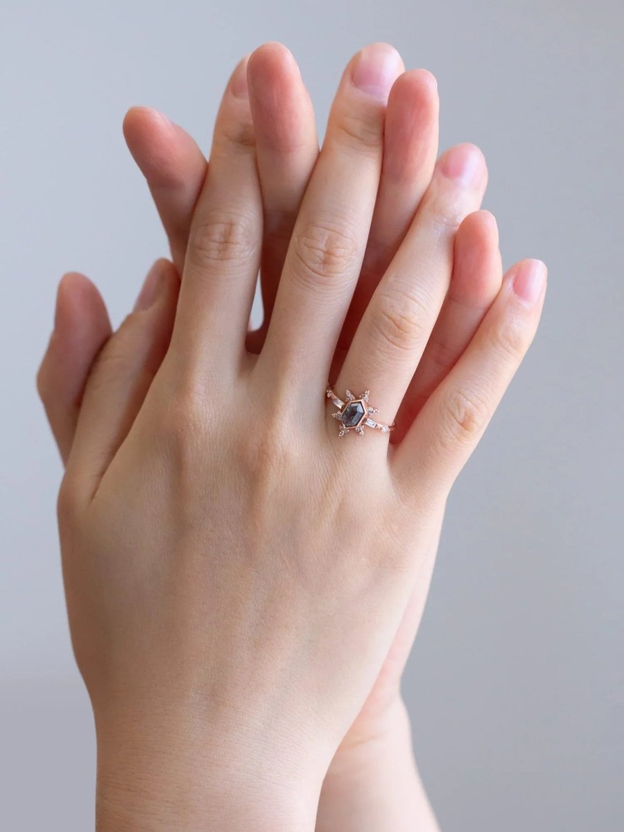 Two hands gently interlocked, with vintage-modern rose gold Art Deco ring on ring finger, highlighting romantic and elegant design