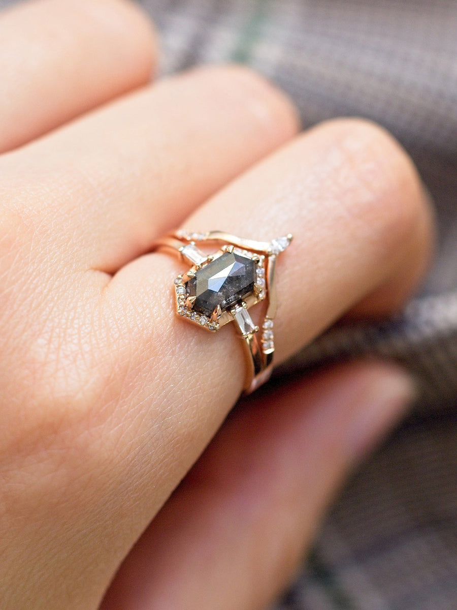 Unique art deco styled hexagon salt and pepper diamond engagement ring in 14k rose gold with baguette and round diamonds on model's hand.