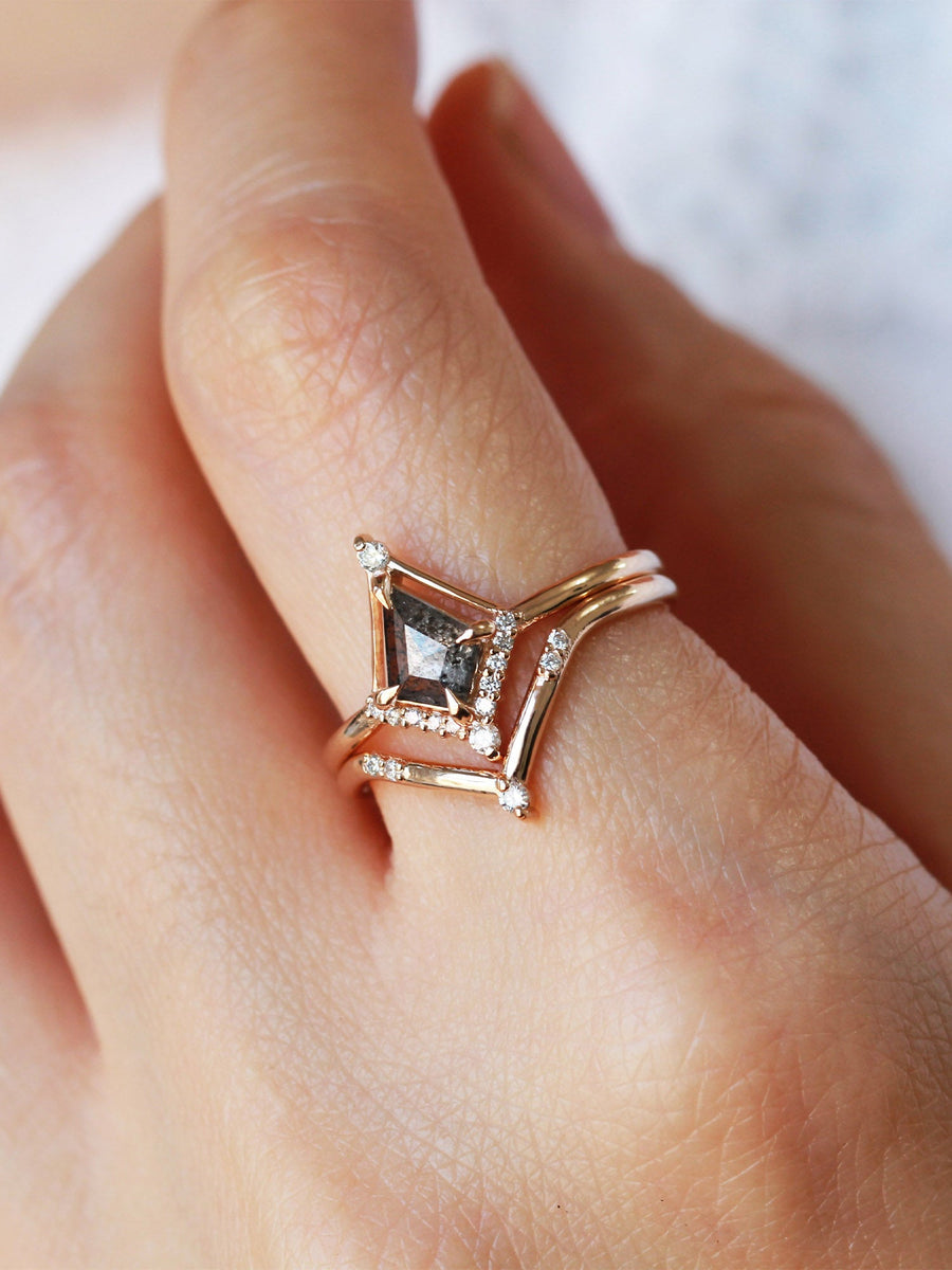 Kite shape salt and pepper diamond engagement ring with smaller round diamonds in 14k gold inspired by the art deco style and minimalism on model’s hand.
