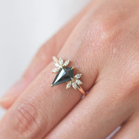 Kite salt and pepper diamond engagement ring in 14k rose gold with four marquise arrangements on each side inspired by the art deco style and minimalism on model's hand.