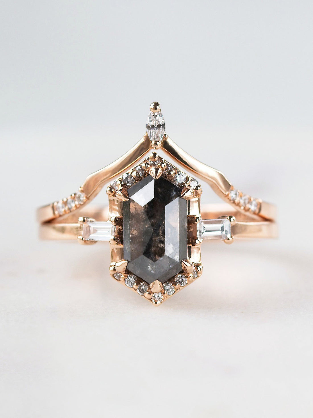 Unique art deco styled hexagon salt and pepper diamond engagement ring in 14k rose gold with baguette and round diamonds with matching band.