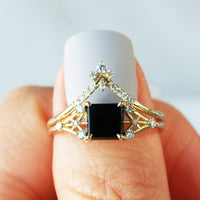 Minimal modern art deco style unique rectangle Onyx engagement ring in 14k gold with smaller round diamonds on model's hand.