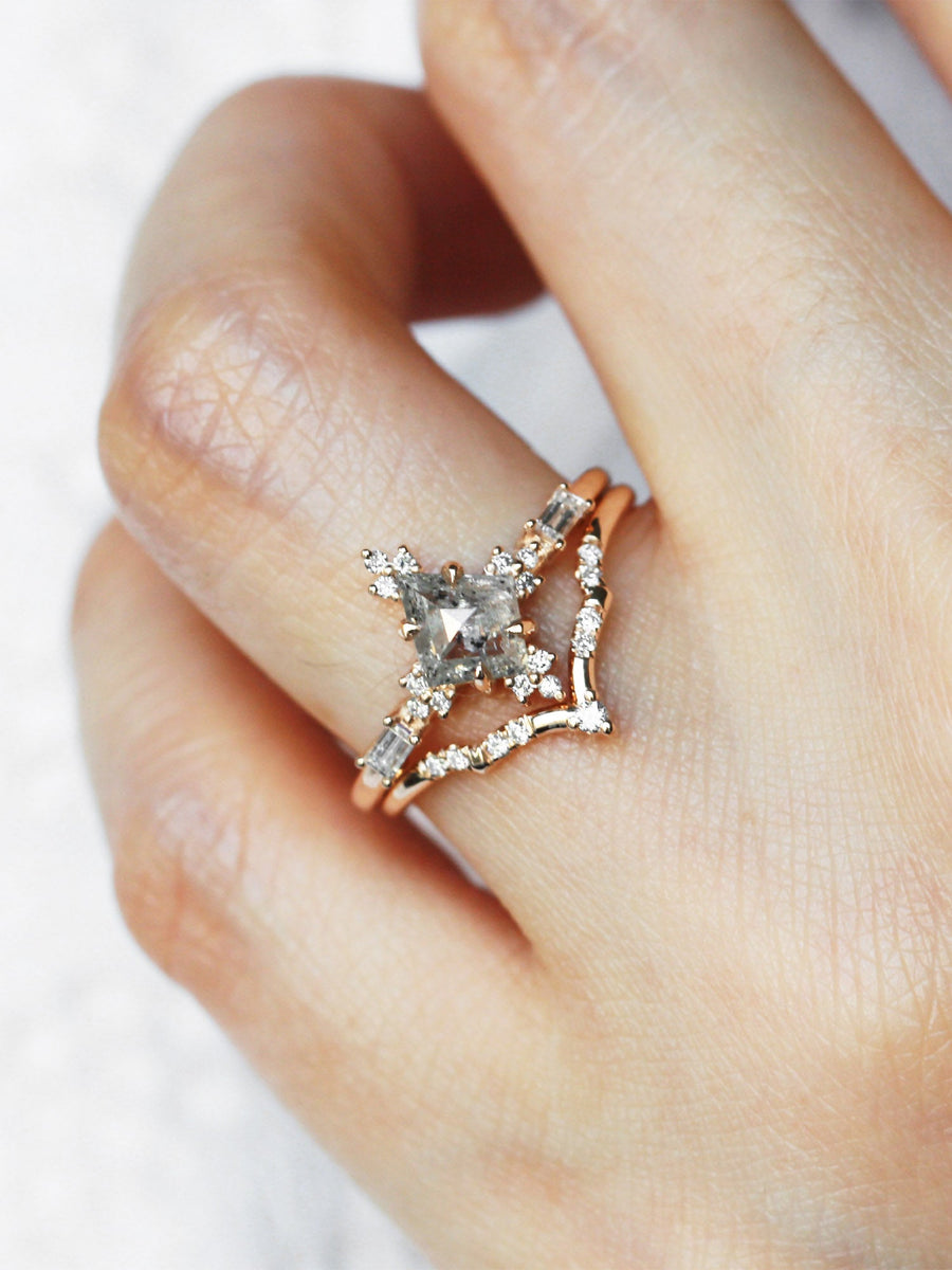 Art deco style minimal kite shape salt and pepper diamond engagement ring in 14k rose gold with smaller baguette and round diamonds on model's hand.