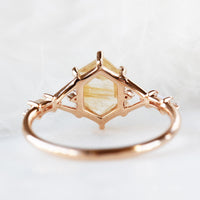 Hexagon rutilated quartz engagement ring in 14k rose gold with smaller baguette and round diamonds inspired by the art deco style and minimalism.