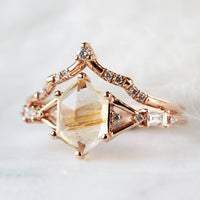 Hexagon rutilated quartz engagement ring in 14k rose gold with smaller baguette and round diamonds inspired by the art deco style and minimalism.